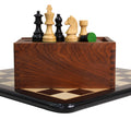 Ebonised Staunton chess pieces on their wooden box and board combo.