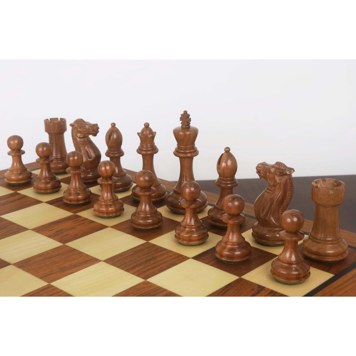 Elegant dark Staunton chess pieces set up on a high-quality 20-inch golden rosewood board.