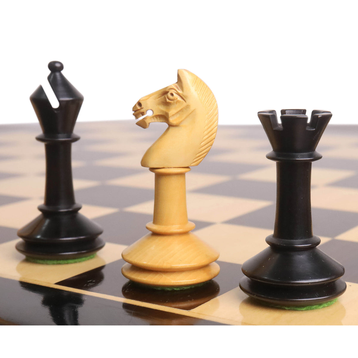 Boxwood knight standing between an ebonised bishop and rook from the 3.5-inch Monolith miniature chess set.