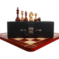 Bud rosewood and boxwood chess pieces staged on a black storage coffer over a wooden board.