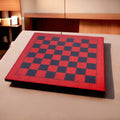 A 22 inch red ash burl and ebony printed chess board displayed in a warm, modern room setting.