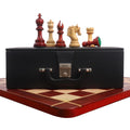 Bud rosewood and boxwood chess pieces arranged on top of a premium black leatherette storage coffer.