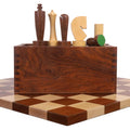 Minimalist golden rosewood and boxwood chess pieces arranged behind their matching wooden storage box.