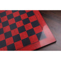 High-gloss finish detail on a red ash burl and ebony printed chess board showing reflective surface and wood grain texture.
