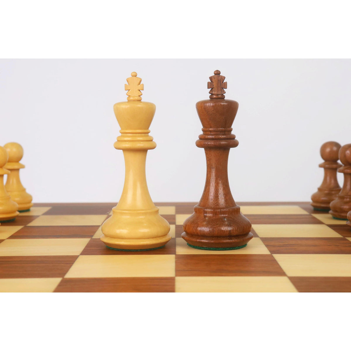 Light and dark Staunton king chess pieces together on the board.