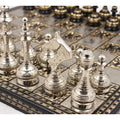 Close-up of silver Soviet-inspired brass chess pieces on a luxury board.
