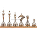 Line-up of silver Soviet-inspired brass metal chess pieces.
