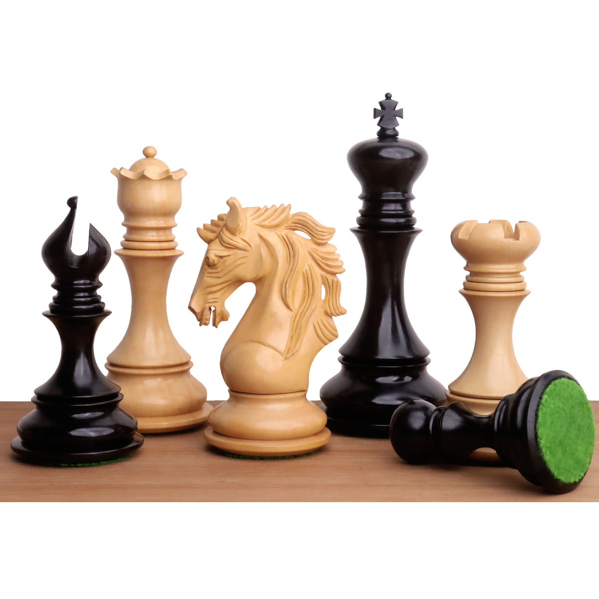 A close-up lineup of Goliath Series Staunton chess pieces in Ebony and Boxwood wood, showcasing their intricate carving and weighted bases.