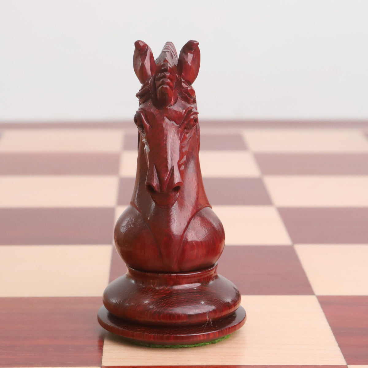 Detailed Bud Rosewood Goliath series Staunton chess Knight on a board.