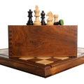 Staunton chess pieces on a storage box and wooden chess board.
