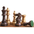 Antiqued copper and brass Pro Staunton chess pieces with a fallen pawn revealing a green felt base.
