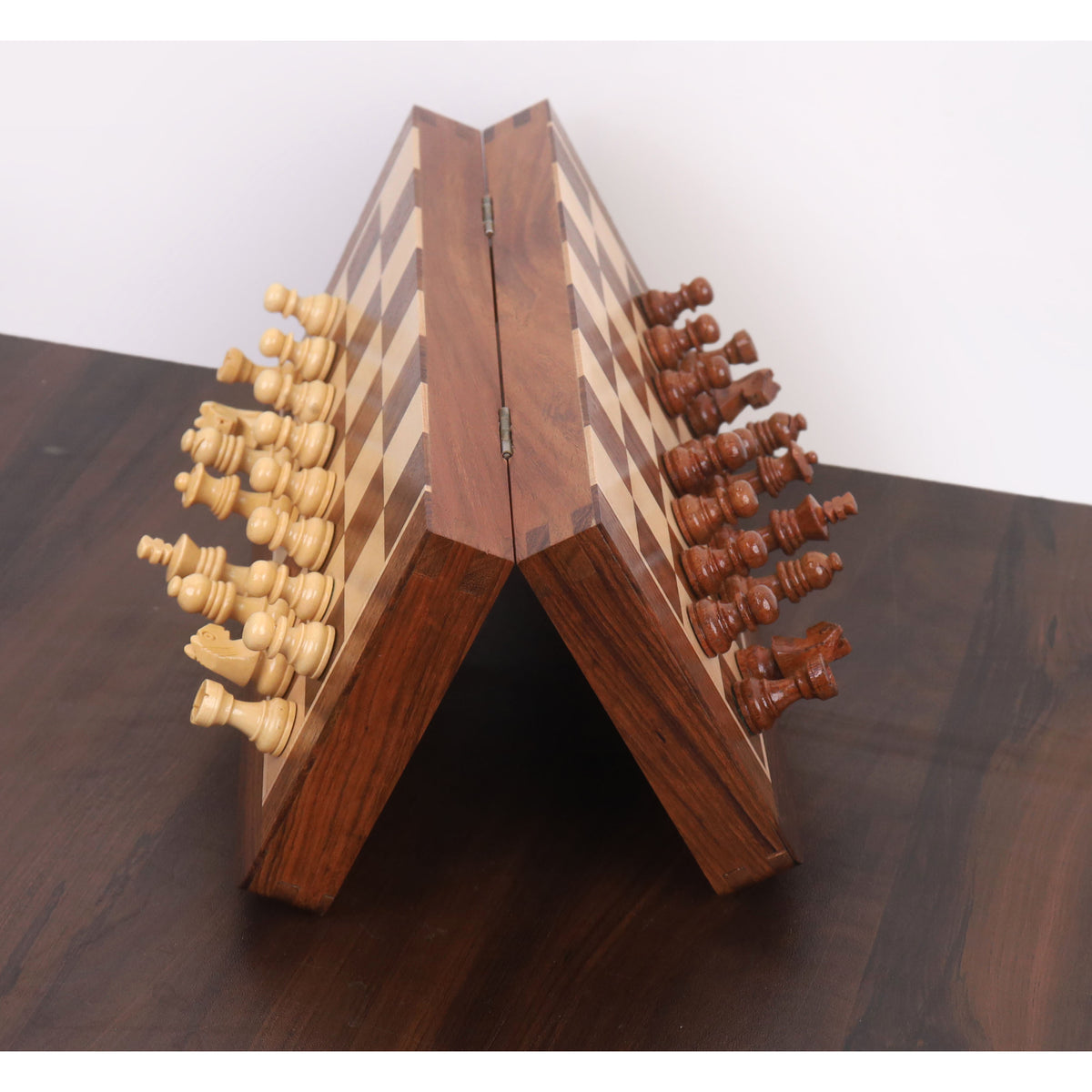 Folding magnetic travel chess set in golden rosewood demonstrating strong magnetic grip.