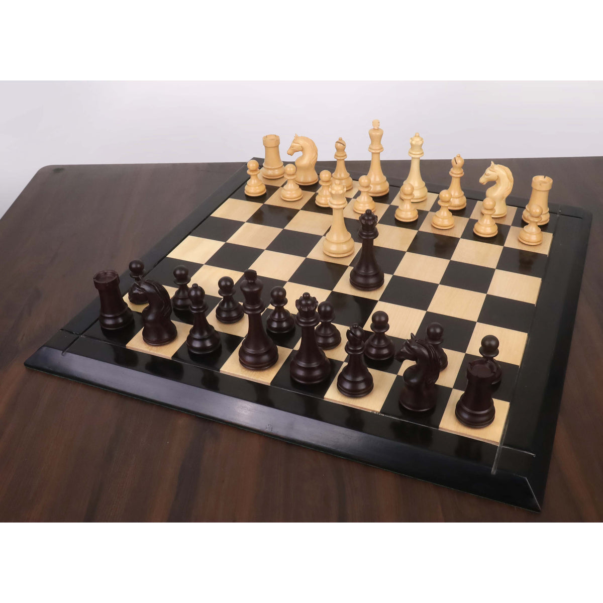 A complete 5-inch Piatigorsky Cup reproduction chess set displayed on a wooden board with extra queens.