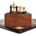 Burnt boxwood Parker Staunton chess pieces on a wooden storage box over an ebony board.