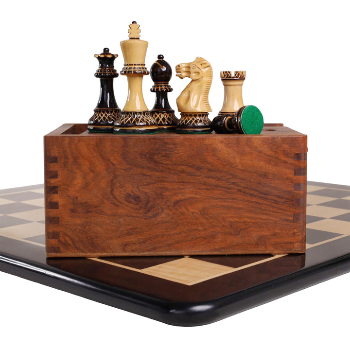 Burnt boxwood Parker Staunton chess pieces on a wooden storage box over an ebony board.