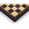 Close-up corner view of 21 inch Queen's Gambit printed chess board in ebony and maple with decorative border.