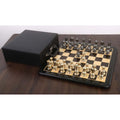 Complete Victorian brass metal chess set on a glossy board with a black storage case.