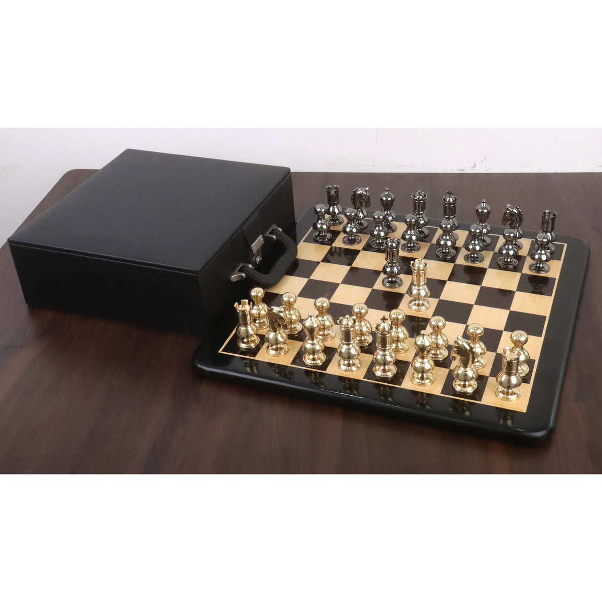 Complete Victorian brass metal chess set on a glossy board with a black storage case.
