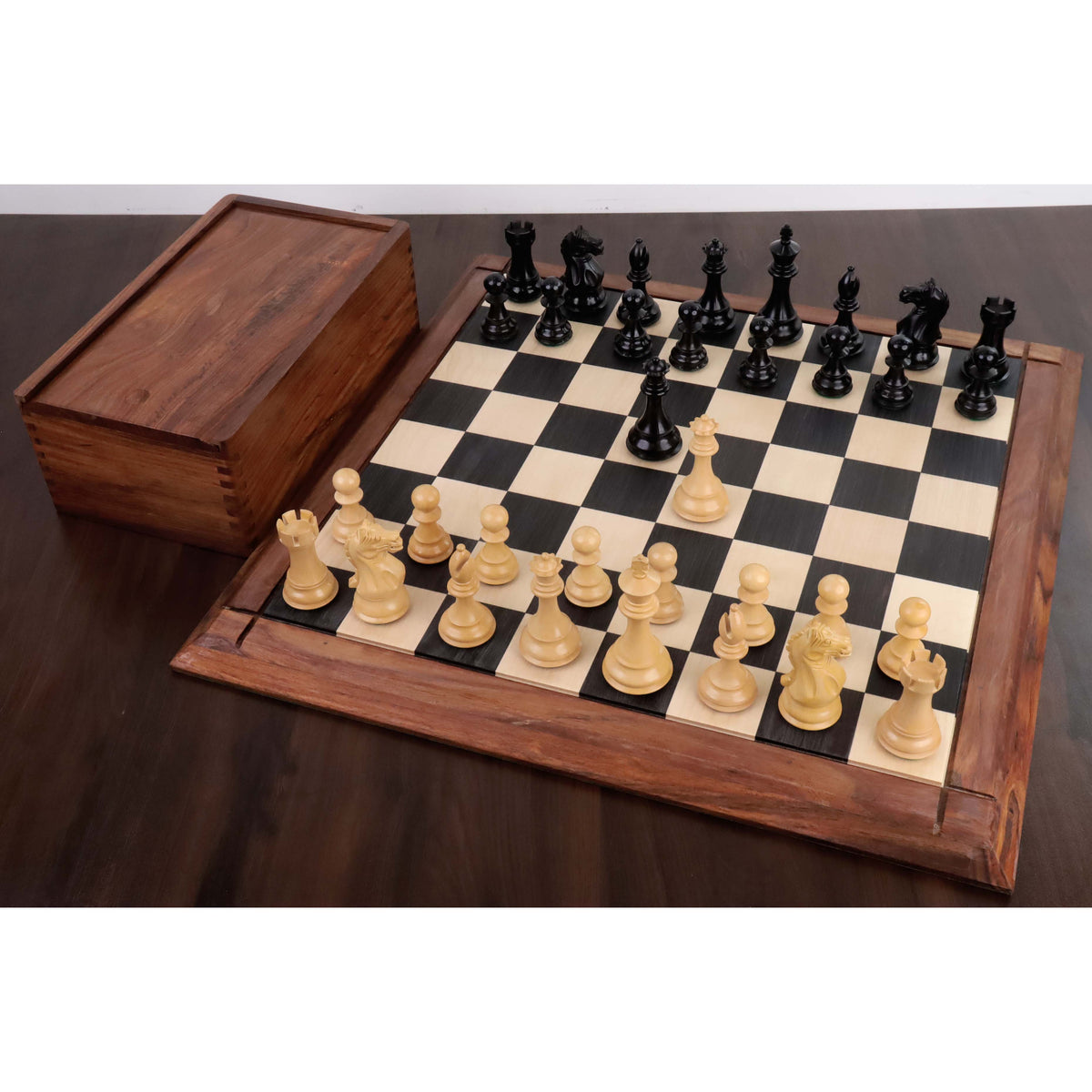 Full set of 4" Fierce Knight Staunton chess pieces in ebonised boxwood displayed on a board with a storage box.