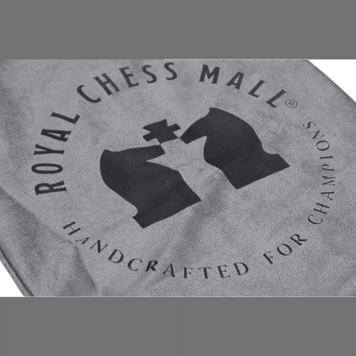 Close-up of the Royal Chess Mall logo printed on a grey velvet travel chess set storage bag.