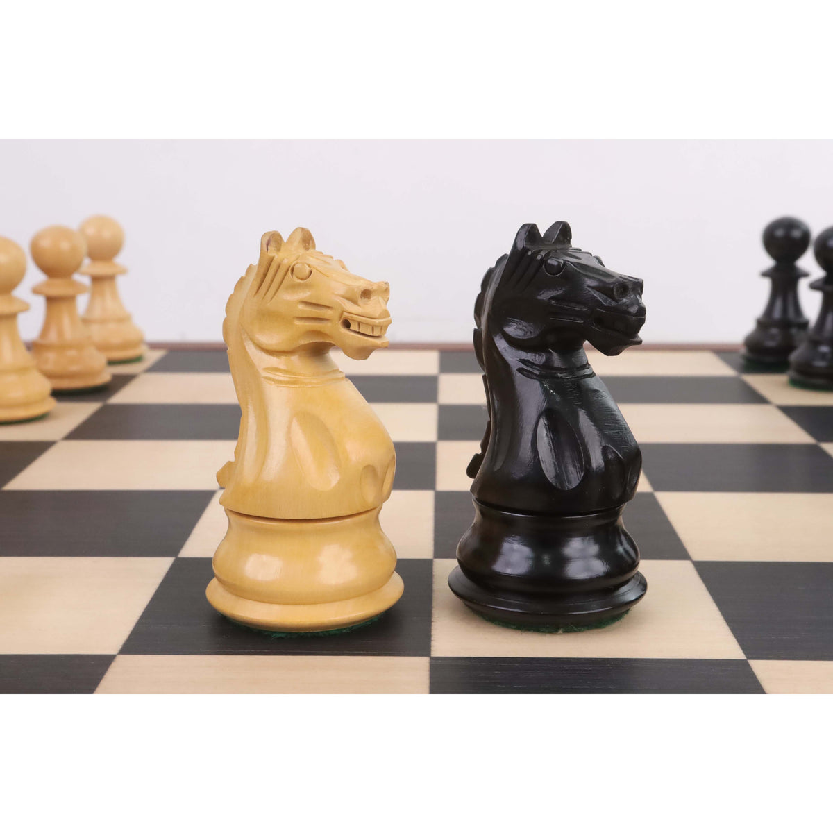 Close-up profile of light and dark knights from the 4" Fierce Knight Staunton chess set in ebonised boxwood.