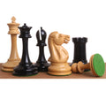 Handcrafted ebony and boxwood luxury chess pieces with green felted bases on a wooden surface.
