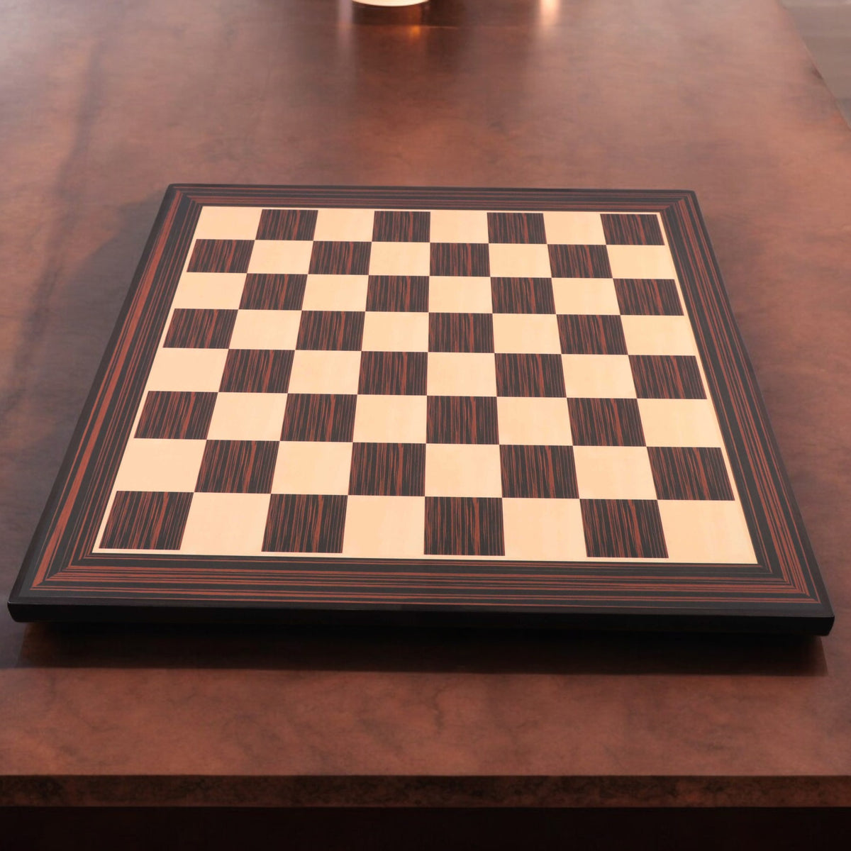 A 21-inch Tiger Ebony and Maple wood printed chess board displayed on a dark wooden table in a lifestyle setting.