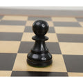 Dark ebonized boxwood pawn from the Reykjavik series positioned on a wooden chessboard square.