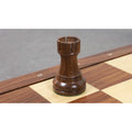 A sturdy Golden Rosewood Rook with classic 1972 Championship proportions on a wooden board.