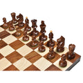 Overhead view of Romanian Hungarian golden rosewood chess pieces set up on a wooden board.