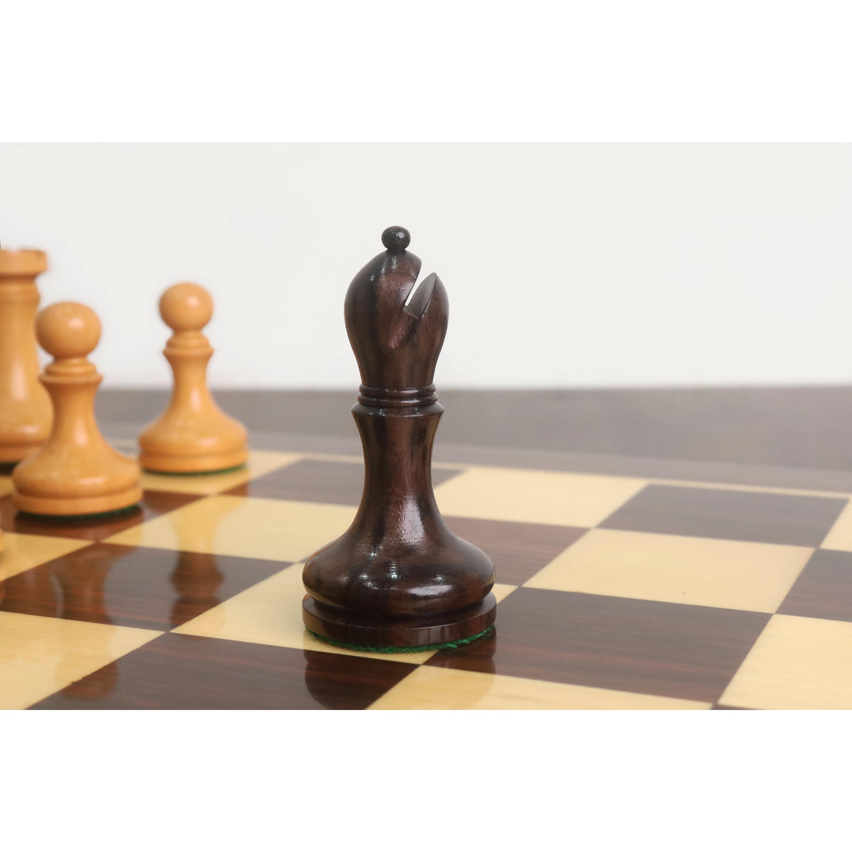 Detailed view of the dark rosewood bishop from the Candidates Series minimalist chess set on a chessboard.