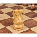 Close-up of a hand-carved Boxwood Staunton Knight piece on a wooden chessboard.