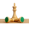 Boxwood king piece standing beside two tipped chess pieces demonstrating the green felted base pads.