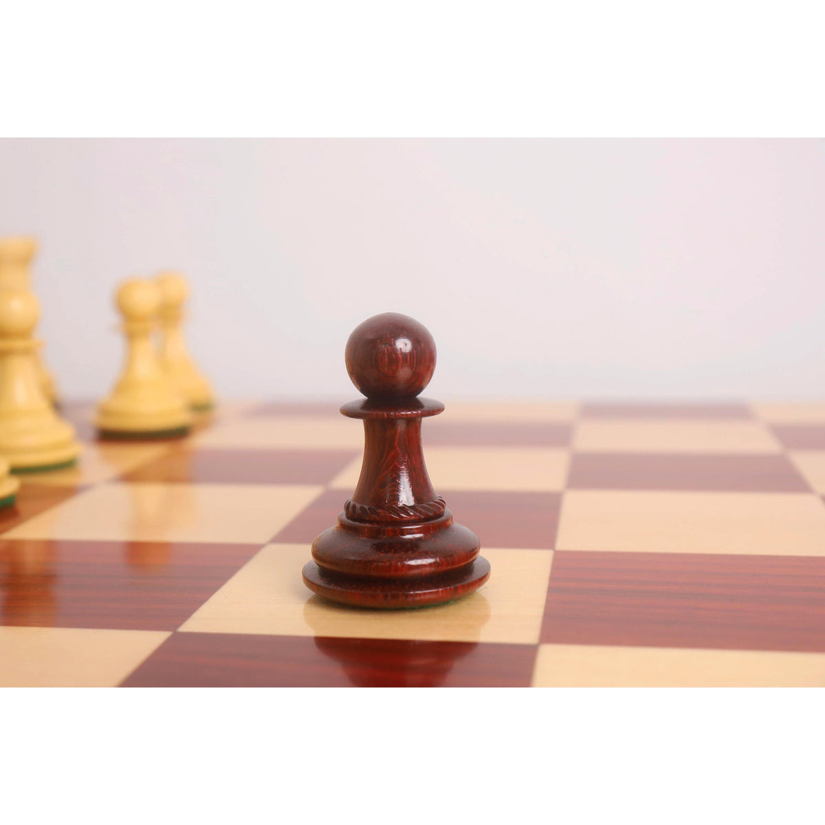 A triple-weighted bud rosewood Pawn piece from the Incitatus luxury Staunton chess set showing its rich wood grain.