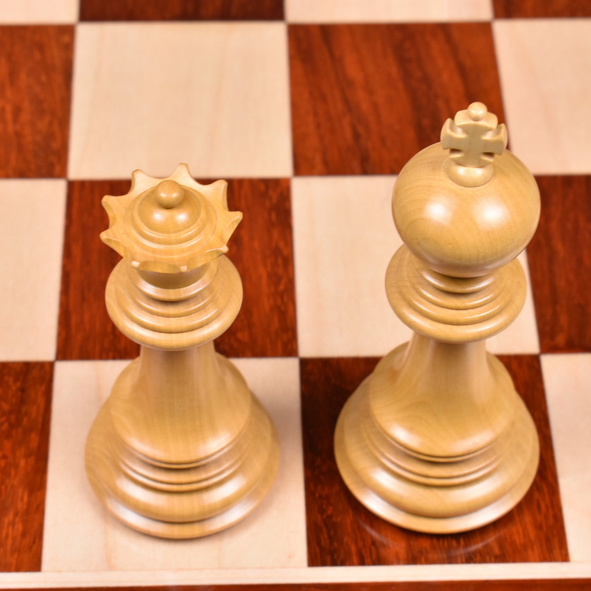 Premium light Boxwood King and Queen chess pieces on a wooden board.