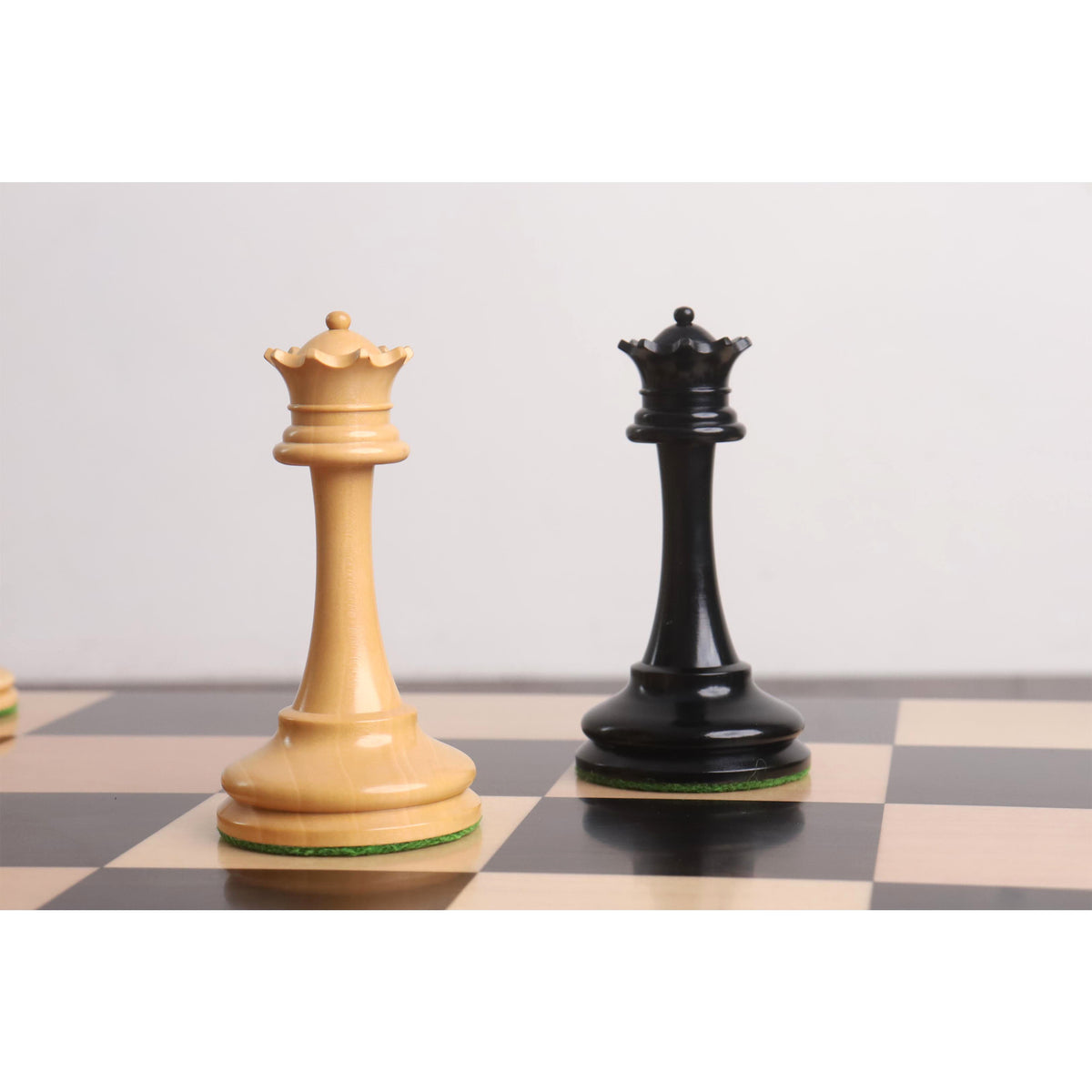 Hand-polished ebony and boxwood Queens featuring ornate coronets from a premium chess set.