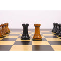 Black and antiqued boxwood Rook chess pieces from the Golden Castle reproduction set on a wooden board.