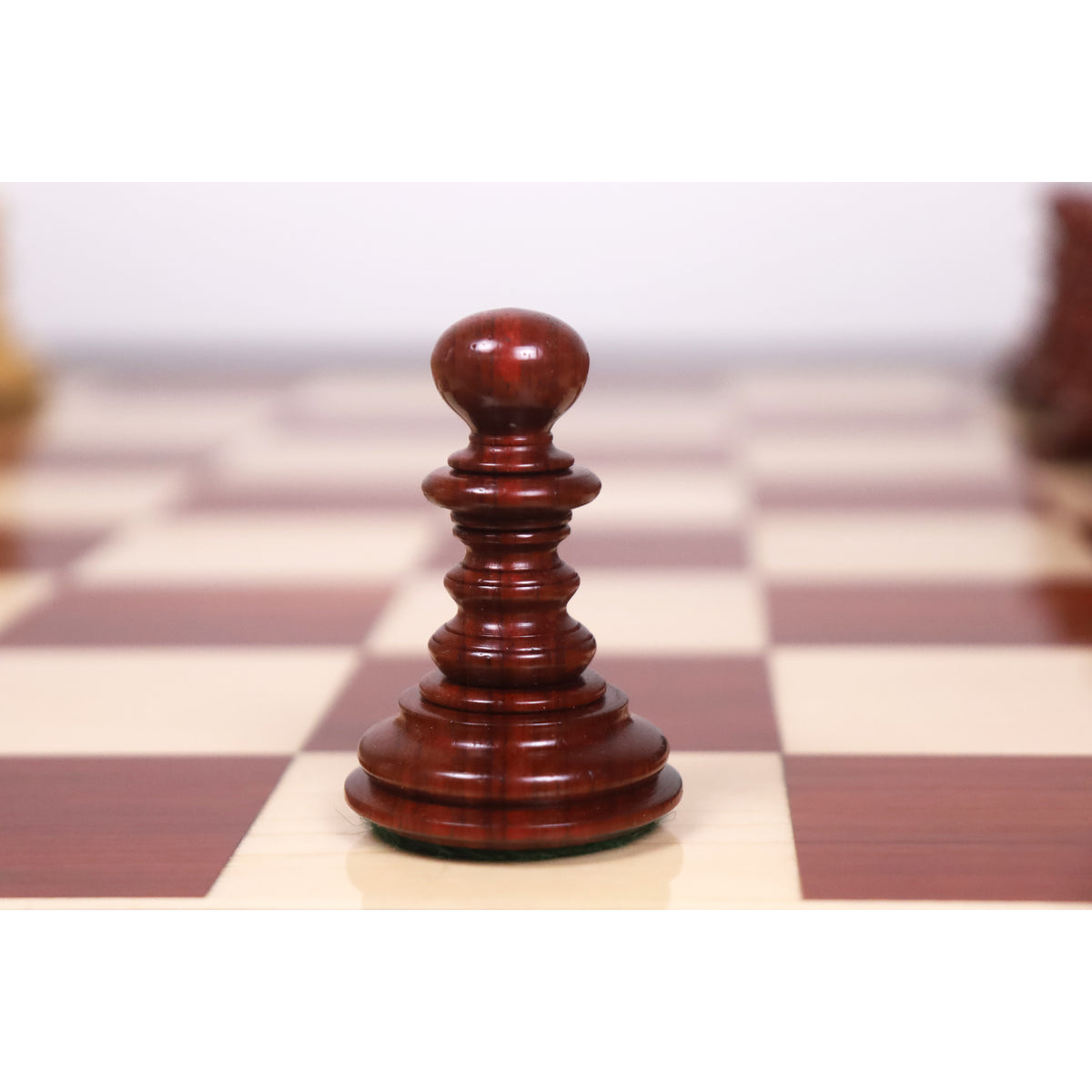 Close-up of a bud rosewood pawn piece from the Marengo luxury Staunton chess set.