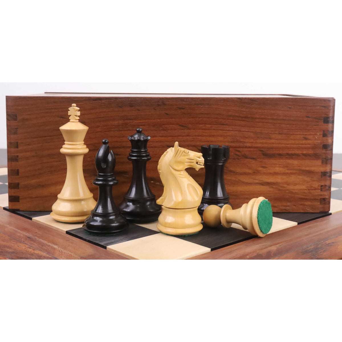 Weighted boxwood and ebonised chess pieces arranged with a premium wooden storage box.
