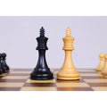 Ebonised boxwood and boxwood king chess pieces displayed on a magnetic travel chess set.