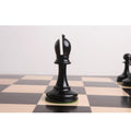 Elegant ebony wood Bishop with a traditional deep mitre cut standing on a wooden chess board.