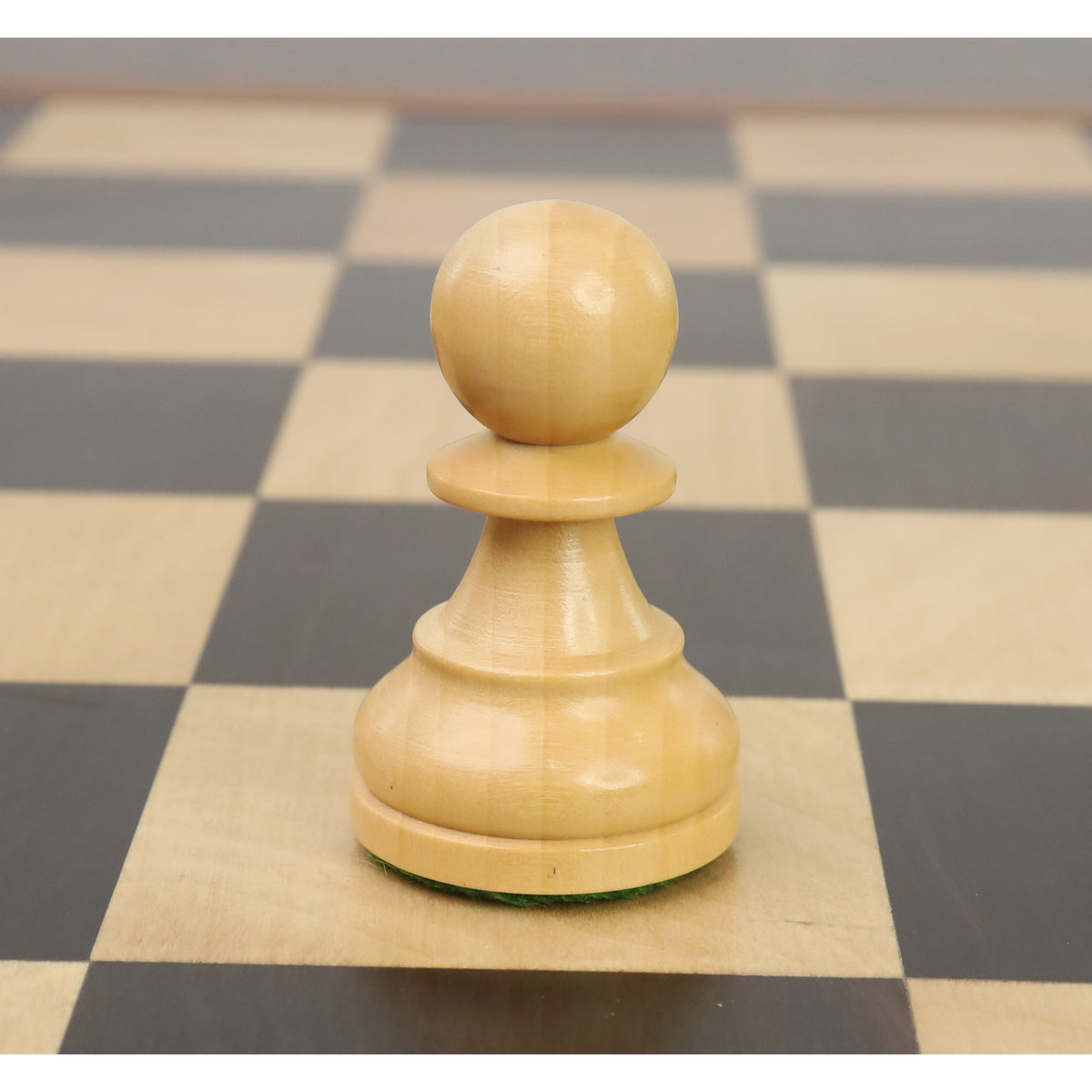 Natural boxwood pawn from the Reykjavik series positioned on a wooden chessboard square.
