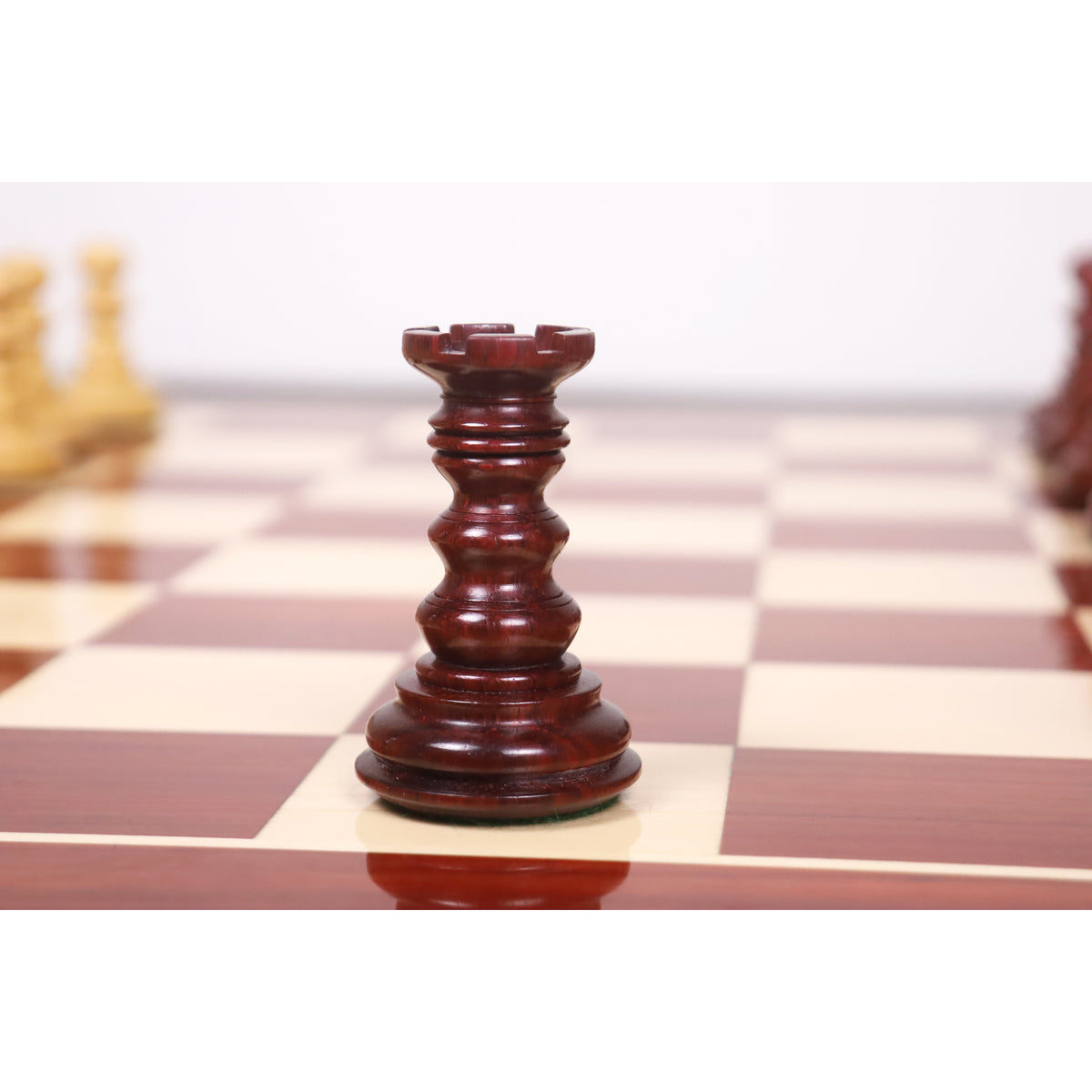 Close-up of a hand-carved bud rosewood rook piece from the Marengo luxury Staunton chess set.