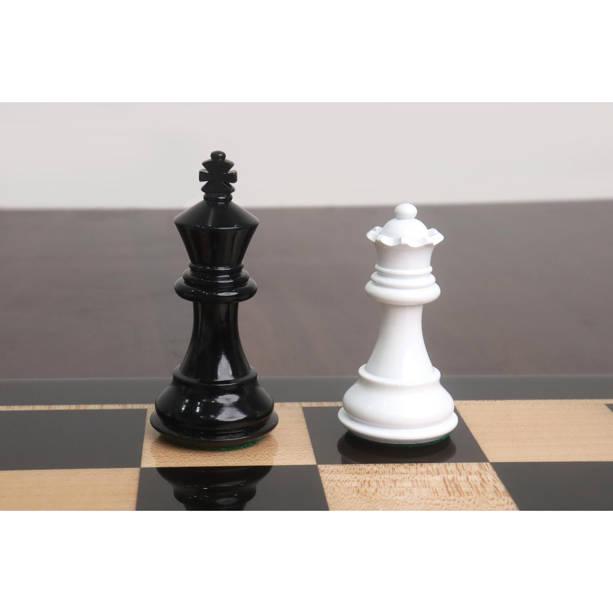 Black king and white queen pieces from the Pro Staunton wooden combo set on an ebony board.