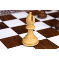 Single Staunton style white bishop chess piece in boxwood, set on an inlaid wooden board.