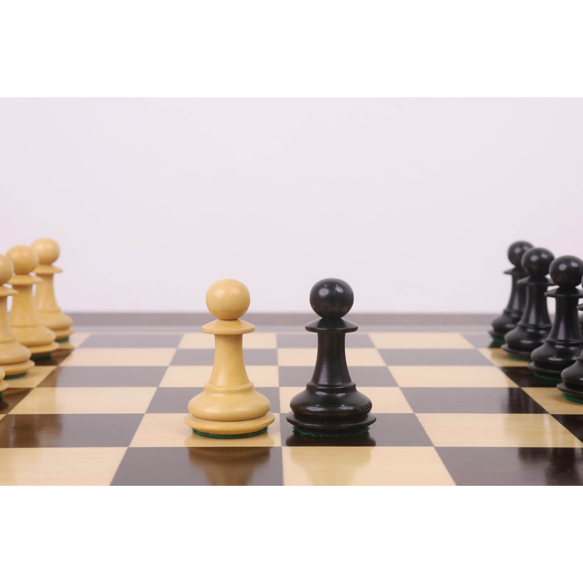 The light and dark wood Pawn pieces from the 3.9" Heritage Series Staunton chess set are positioned centrally on a chessboard.