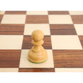 Close-up of a natural boxwood pawn from the tournament Staunton set sitting on a wooden board.