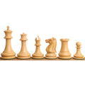 Full lineup of 1849 Jacques Cook Staunton boxwood chess pieces from King to Pawn on a wooden ledge.