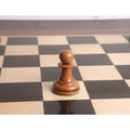 Distressed antiqued boxwood pawn from the reproduced 1849 Original Staunton series on a dark wood board.