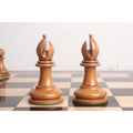 Two 1849 Staunton bishops in distressed antiqued boxwood finish on a chess board.